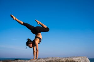 woman with legs outstretched against blue sky - yoga